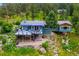Aerial view of property featuring a large outdoor deck, spiral staircase, and wooded surroundings at 6565 Marshmerry Ln, Evergreen, CO 80439