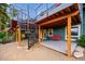 Backyard features a spiral staircase to the upper balcony with a covered deck below complete with a cozy swing at 6565 Marshmerry Ln, Evergreen, CO 80439