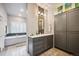 Stylish bathroom features sleek gray cabinetry, modern fixtures, and a luxurious soaking tub at 6565 Marshmerry Ln, Evergreen, CO 80439