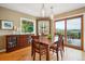 Dining area featuring hardwood floors, built-in storage, and sliding door access to the outside deck at 6565 Marshmerry Ln, Evergreen, CO 80439