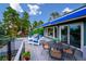 Deck overlooking mature trees and mountain views with a table and seating area at 6565 Marshmerry Ln, Evergreen, CO 80439