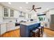 Bright kitchen features a large island with seating, stainless steel appliances, and wooden floors at 6565 Marshmerry Ln, Evergreen, CO 80439