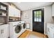 Convenient laundry room featuring modern washer/dryer, ample storage, and exterior door at 6565 Marshmerry Ln, Evergreen, CO 80439
