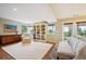Bright living room boasts built-in bookshelves and access to a patio with incredible views at 6565 Marshmerry Ln, Evergreen, CO 80439