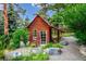 Cozy outbuilding nestled among trees with a charming entrance and surrounding greenery at 6565 Marshmerry Ln, Evergreen, CO 80439