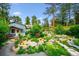 Beautifully landscaped yard with lush greenery, stone pathways, and charming garden features at 6565 Marshmerry Ln, Evergreen, CO 80439