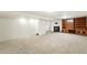 Large finished basement featuring a cozy fireplace, built-in bookcase, and soft carpeting at 470 S Queen St, Lakewood, CO 80226