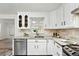 Bright kitchen with updated appliances, white cabinets, and a functional layout perfect for cooking and entertaining guests at 470 S Queen St, Lakewood, CO 80226
