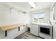 Well-lit laundry room with utility sink, convenient folding table, and organized shelving above at 470 S Queen St, Lakewood, CO 80226