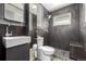 Modern bathroom featuring a unique sink, toilet, and stylish shower with sleek tile and stone pebble floor at 7296 Quivas St, Denver, CO 80221