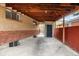 Carport featuring exposed wood rafters and a concrete floor, offering covered parking at 7296 Quivas St, Denver, CO 80221