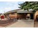 Lovely brick home featuring decorative rock landscaping, a fenced yard, and a convenient attached carport at 7296 Quivas St, Denver, CO 80221