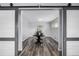 A flex room with sliding doors leading to a dining area, wood-style floors, and a neutral color palette at 7296 Quivas St, Denver, CO 80221