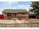 A beautiful brick home with a manicured front yard, secure front door, and a convenient attached carport at 7296 Quivas St, Denver, CO 80221
