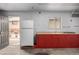 Garage area featuring red cabinets, a sink, and access to the backyard patio at 7296 Quivas St, Denver, CO 80221