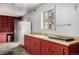 Garage with red cabinets, countertop space, a utility sink, and access to shelving on the back wall at 7296 Quivas St, Denver, CO 80221
