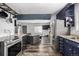 Open layout connecting the kitchen to the living room, featuring stainless steel appliances and unique flooring at 7296 Quivas St, Denver, CO 80221