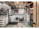 Functional laundry room with washer, dryer, utility sink, and storage shelves at 7296 Quivas St, Denver, CO 80221