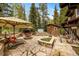 Charming stone patio with a fire pit, hot tub, lounge chairs, umbrellas, and professional landscaping create an outdoor oasis at 215 Royal Tiger Rd, Breckenridge, CO 80424