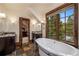 Spacious bathroom with dual sinks, soaking tub, and scenic views from the expansive window at 215 Royal Tiger Rd, Breckenridge, CO 80424
