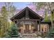 Detailed wood-clad entrance featuring a covered porch and stone accents, framed by lush greenery at 215 Royal Tiger Rd, Breckenridge, CO 80424