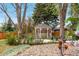 Landscaped backyard with a gazebo, mature trees, and stone pathways at 6919 S Valentia St, Centennial, CO 80112
