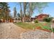 Large, fenced backyard featuring a gazebo, mature trees, and garden beds at 6919 S Valentia St, Centennial, CO 80112