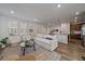 Living room showcasing wood floors and an open layout seamlessly connecting to the kitchen at 9536 Richfield St, Commerce City, CO 80022