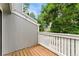Private outdoor balcony featuring wood decking and white railing overlooking lush greenery at 1160 S Monaco Pkwy # 6, Denver, CO 80224