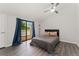 Cozy bedroom with wood floors, a ceiling fan, and sliding doors to a private balcony at 1160 S Monaco Pkwy # 6, Denver, CO 80224