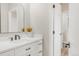 Bright bathroom featuring a white vanity with black hardware, a modern mirror, and a doorway into another room at 14850 Akron St, Brighton, CO 80602