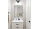 Bright bathroom featuring a white vanity, black hardware, and a modern light fixture over the mirror at 14850 Akron St, Brighton, CO 80602
