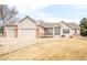 Well-manicured lawn complements this home, boasting a three-car garage and appealing curb appeal at 14850 Akron St, Brighton, CO 80602