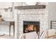 Close-up of a stone fireplace with a wooden mantel and burning fire at 14850 Akron St, Brighton, CO 80602