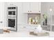 Bright kitchen with stainless steel double ovens and stylish white cabinetry and countertops at 14850 Akron St, Brighton, CO 80602