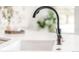 A close-up of a modern kitchen sink with a sleek black faucet at 14850 Akron St, Brighton, CO 80602