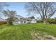 Exterior view of the home showcasing the large yard and mature trees at 10020 Bryant St, Denver, CO 80260