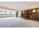 Finished basement featuring a brick fireplace with wood storage and neutral carpeting at 10020 Bryant St, Denver, CO 80260