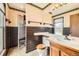 Bathroom featuring wallpaper, black tile walls, and a wooden vanity at 10020 Bryant St, Denver, CO 80260