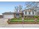 Charming home with a well-manicured lawn, brick accents, and a two-car garage on a sunny day at 10020 Bryant St, Denver, CO 80260
