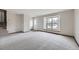 Sunlit living room boasts large windows, neutral carpet, and easy access to the staircase at 10020 Bryant St, Denver, CO 80260