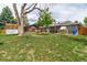 Expansive backyard featuring a patio, greenhouse, large shade tree and open green space at 2612 Meadowbrook Dr, Denver, CO 80221