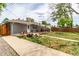 Well-manicured backyard with a patio, fire pit, greenhouse, and lush green grass at 2612 Meadowbrook Dr, Denver, CO 80221