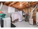 Unfinished basement area with laundry hookups and utility equipment at 2612 Meadowbrook Dr, Denver, CO 80221