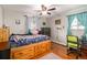 Bright bedroom with hardwood floors, a ceiling fan, and a built-in bed with ample storage drawers at 2612 Meadowbrook Dr, Denver, CO 80221