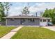 Inviting single-level home with gray brick, a manicured lawn, and a welcoming pathway to the front entrance at 2612 Meadowbrook Dr, Denver, CO 80221