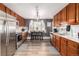 View of updated kitchen featuring stainless steel appliances and eat in dining area with natural light at 2612 Meadowbrook Dr, Denver, CO 80221