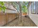 Narrow backyard with wood fencing, small gravel area, and tall tree providing some shade at 1145 S Boston St, Denver, CO 80247