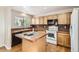 Cozy kitchen features an island, wood cabinets, and tiled countertops at 1145 S Boston St, Denver, CO 80247