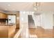 Bright living room featuring hardwood floors, staircase, and kitchen with wood cabinets at 1145 S Boston St, Denver, CO 80247